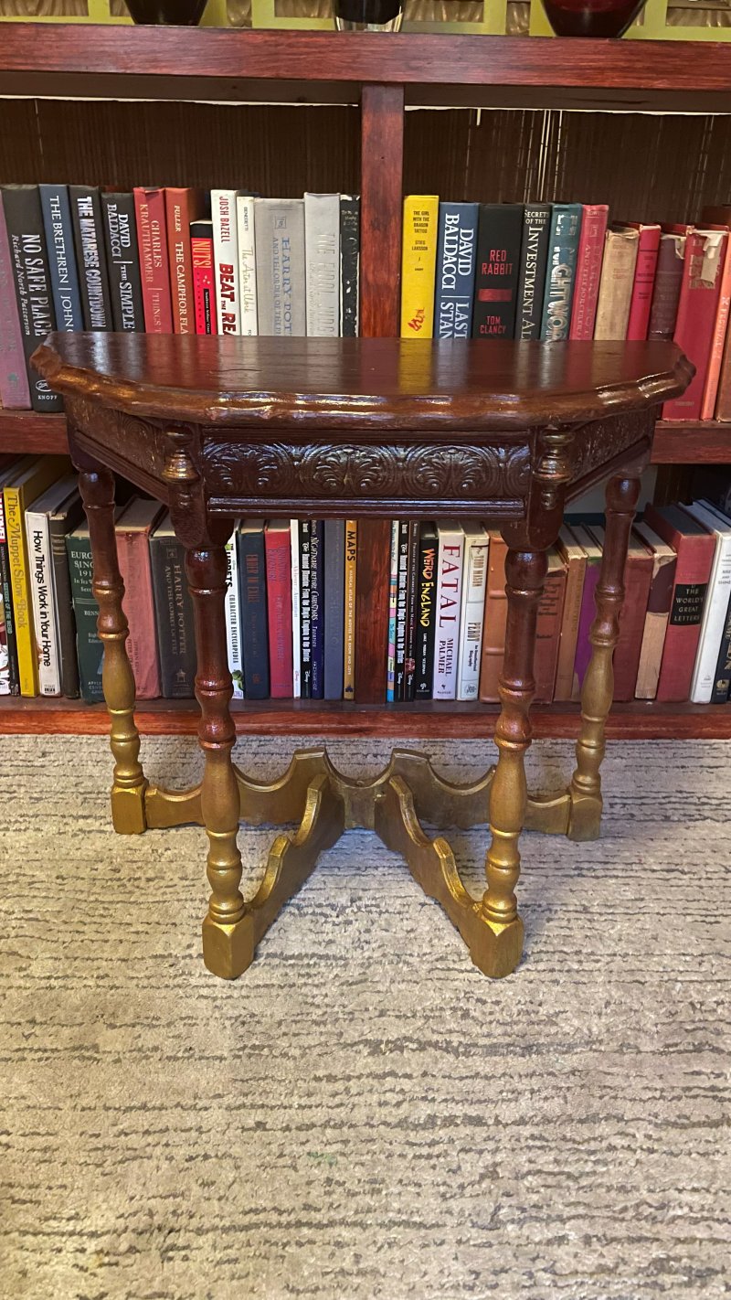 Carved demilune console table with turned, gilt-accented legs